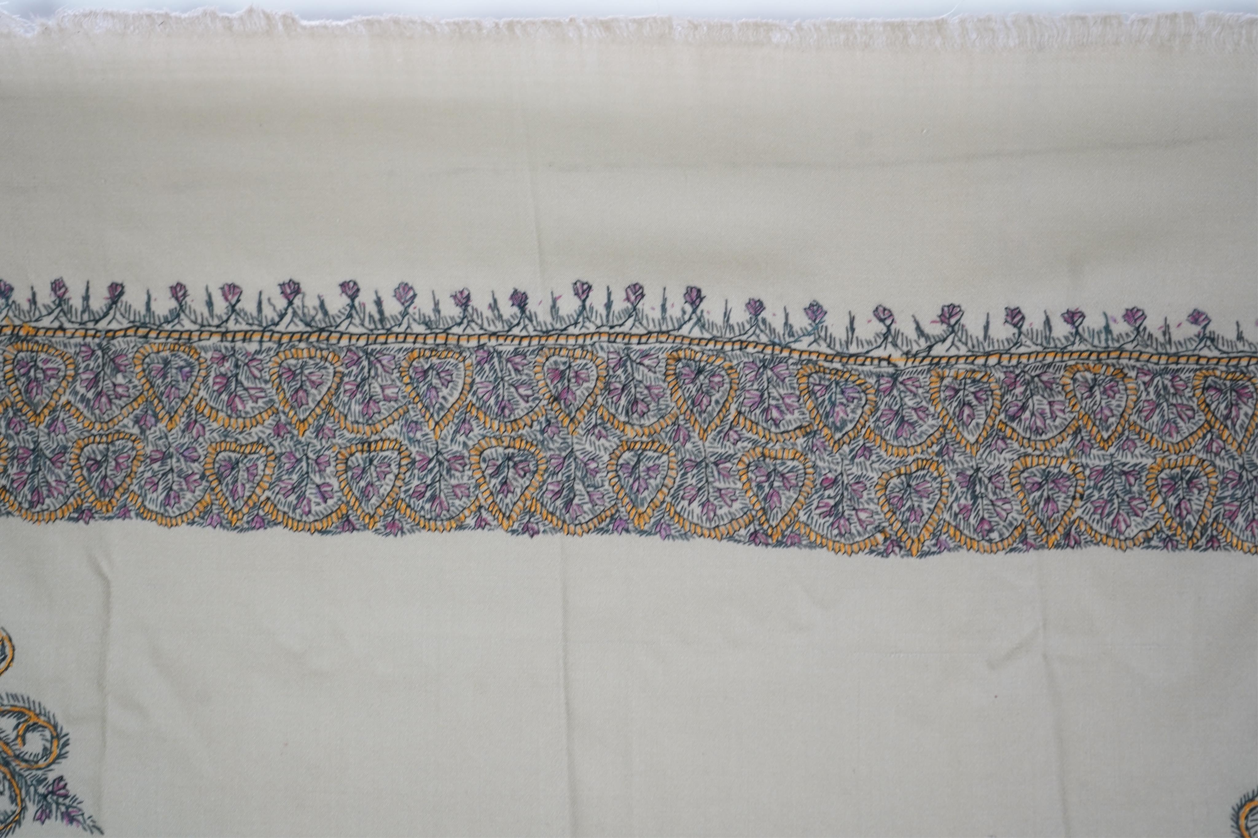 A 20th century ladies mushroom coloured Kashmiri black, yellow and grey silk embroidered stole, with two fine fringe edges, 190 cm long. Condition - a small moth hole near the embroidered border and one mark near one end